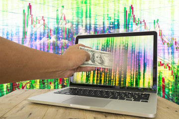 Fintech for investment concept image. Hand pull money out of computer screen with binary code...