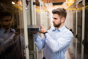 Technician removing server from rack mounted server