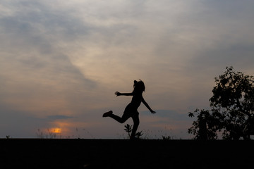 Fototapeta na wymiar Silhouette girls on holiday. she is happy to be running and jump