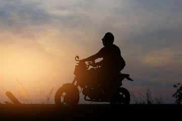 Fototapeta na wymiar Silhouette People riding a motorcycle at sunset