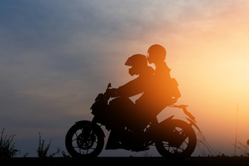 Fototapeta na wymiar Silhouette People riding a motorcycle at sunset