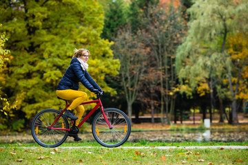 Fototapeta premium Urban biking - woman riding bike in city park 
