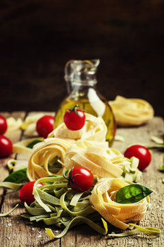 Still life in rustic style. Nest of pasta with cherry tomatoes,