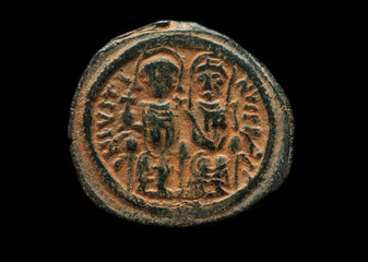 Ancient copper coin with figures of rulers