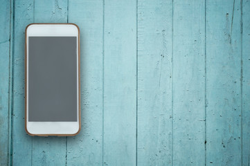 Blank screen phone on wood background.