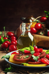 Salad of colorful tomatoes on plate. Vintage wooden background,