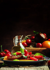 Salad of colorful tomatoes on plate. Vintage wooden background,