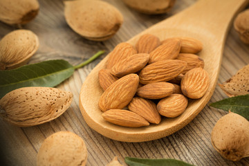 Almonds on brown wooden background