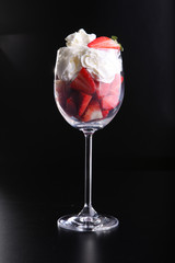 Strawberries and whipped cream in glass.