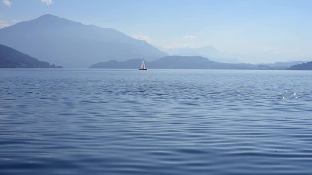 ein Segelboot auf dem Zuger See mit Alpenkulisse im Hintergrund