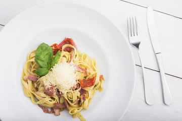 Italian pasta with sauce, bacon, tomato and parmesan