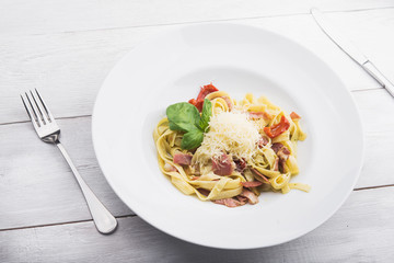 Italian pasta with sauce, bacon, tomato and parmesan