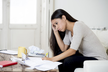 young attractive latin woman at home living room couch calculating monthly expenses worried in...