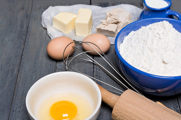 Ingredients for baking yeast cake, wooden background.