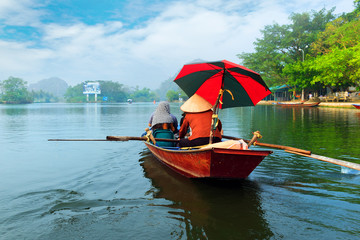 Travel by boat in flooded areas submerged trees in YEN stream, Myduc, Hanoi, Vietnam.