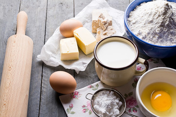 Ingredients for baking yeast cake, wooden background.