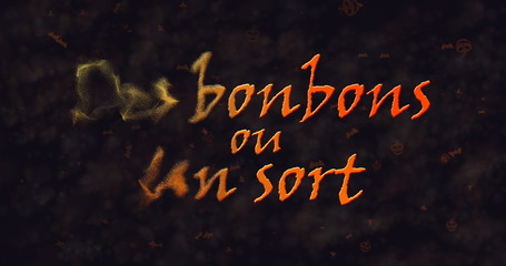 Des bonbons uo un sort (Trick or Treat) French text dissolving into dust from left.