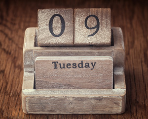 Grunge calendar showing Tuesday the ninth on wood background