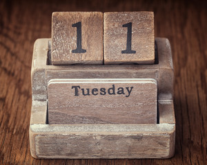 Grunge calendar showing Tuesday the eleventh on wood background