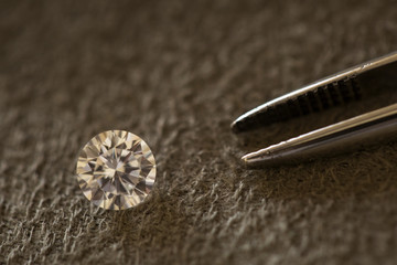 loose brilliant diamond with tweezers 