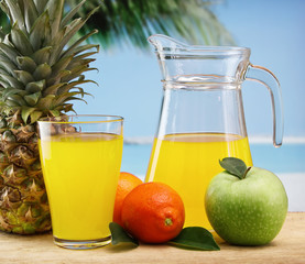 variety of fruit and juice  on a beach table
