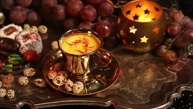 Traditional Oriental Sweets on Vintage Moroccan Tray. Cup of Saffron Masala Tea with spices. Gala dinner by candlelight. Arab, African, Turkish, Persian and Indian silver dishes (Kitchen Utensils)