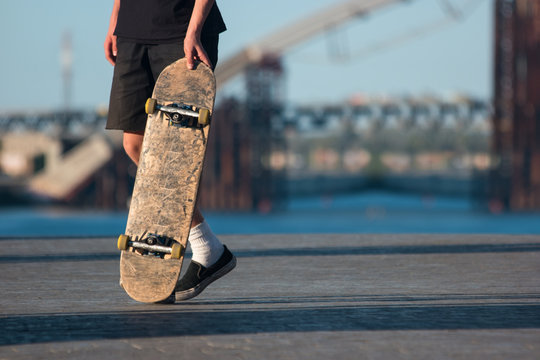 Guy with skateboard. Skater on blurred background. Be bold and risky. Sport that grew into culture.