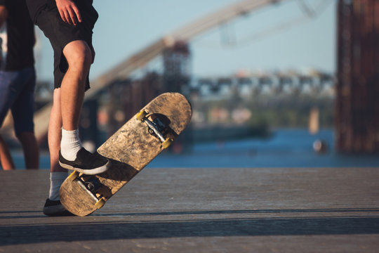 Feet of person with skateboard. Skateboarder in shorts. Sport of the bold. Love what you do.