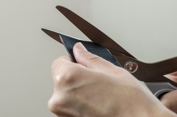 Physiotherapist cutting on black kinesio tape with a scissors