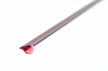 Detail of syringe needle with a drop of blood isolated