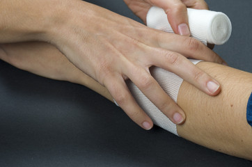 Close-up of woman doctor bandaging a hand