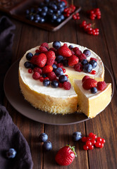 Homemade cheese cake with strawberry and winter berries. New York Cheesecake cake. Christmas dessert. Healthy food. Creative atmospheric decoration.