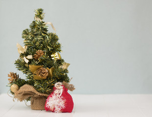 Christmas tree in the sacking on a wooden table.