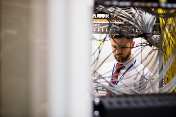 Technician checking cables in a rack mounted server