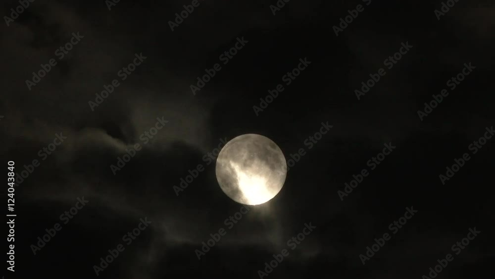 Canvas Prints clouds part and reveal bright full moon on cloudy night.