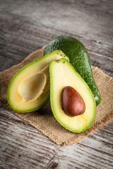 Close-up of an avocado and avocado oil on wooden table. Healthy food concept. © jeny_lk