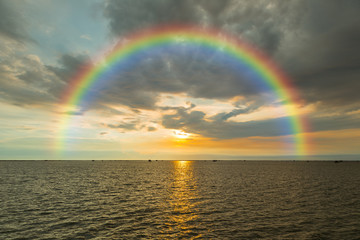 Seascape with rainbow during sunset