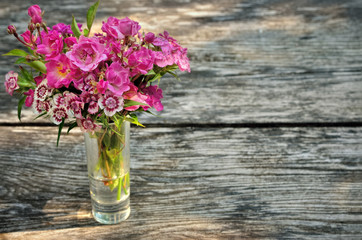 Bouquet of small carnations on a table in the garden