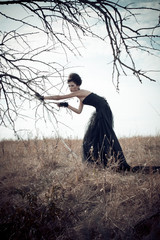Dark Queen in park. Fantasy black dress.