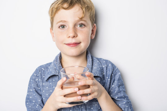 Happy Smiling Child Drinking Chocolate Milk Isolated On White