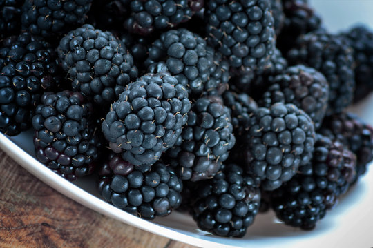Fresh ripe blackberries in white bowl