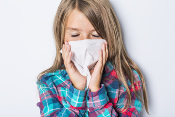 girl sneeze with napkin paper on white background