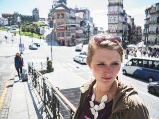 Junge Frau steht an einer Bahnstation in Portugal