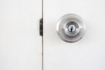 Doorknob in wooden door close up.