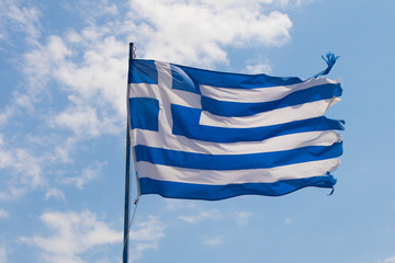 Greece flag against blue sky with white clouds
