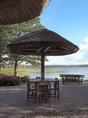 Wooden tables with straw roof.