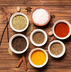 Spices on brown rustic wooden background, soft focus, square
