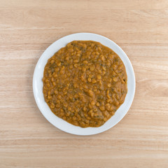 Spinach and lentils on a plate atop a wood table