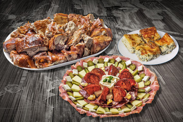 Appetizer Dish Meze With Plateful of Spit Roasted Pork And Cheese Pie Slices On Old Cracked Flaky Wooden Garden Table