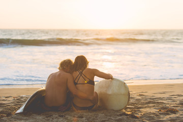 Couple of surfers sharing love emotions on the beach